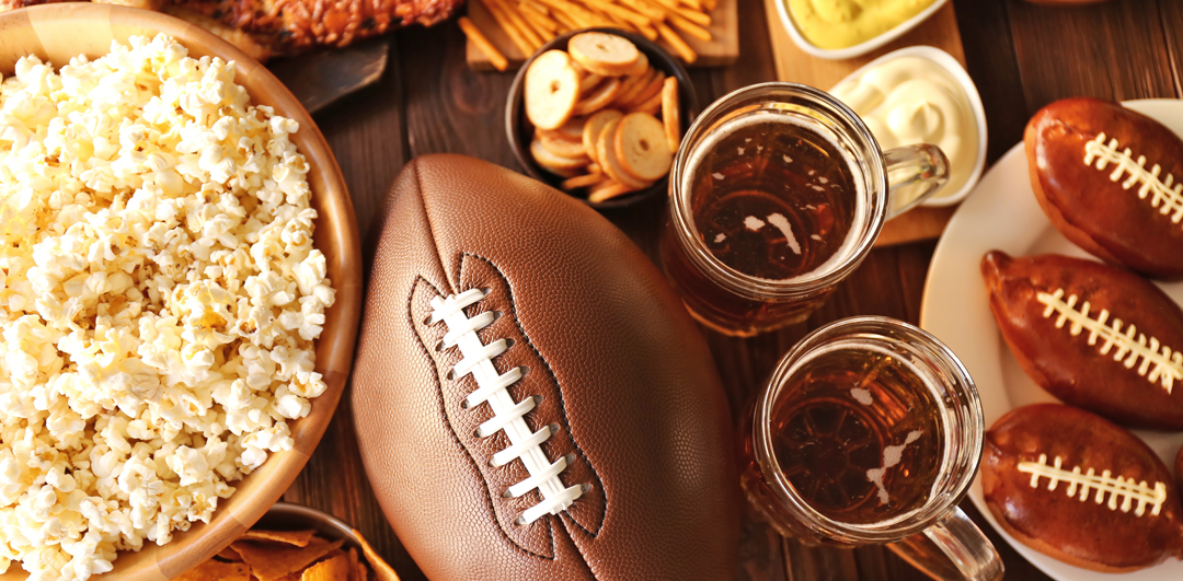 table of football party foods including a bowl of popcorn