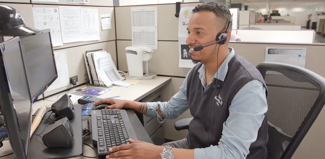 customer service rep sitting at desk and wearing headset