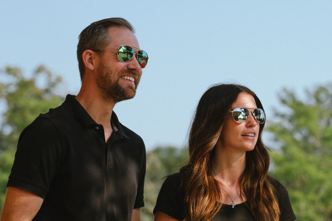 Man and woman wearing aviator sunglasses outside