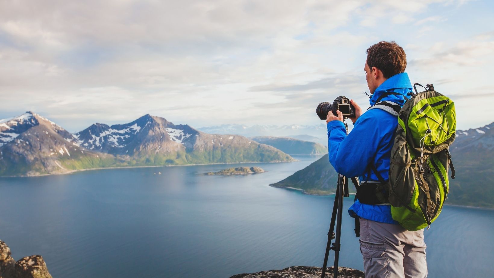 Man taking a photo of mountains with a DSLR camera