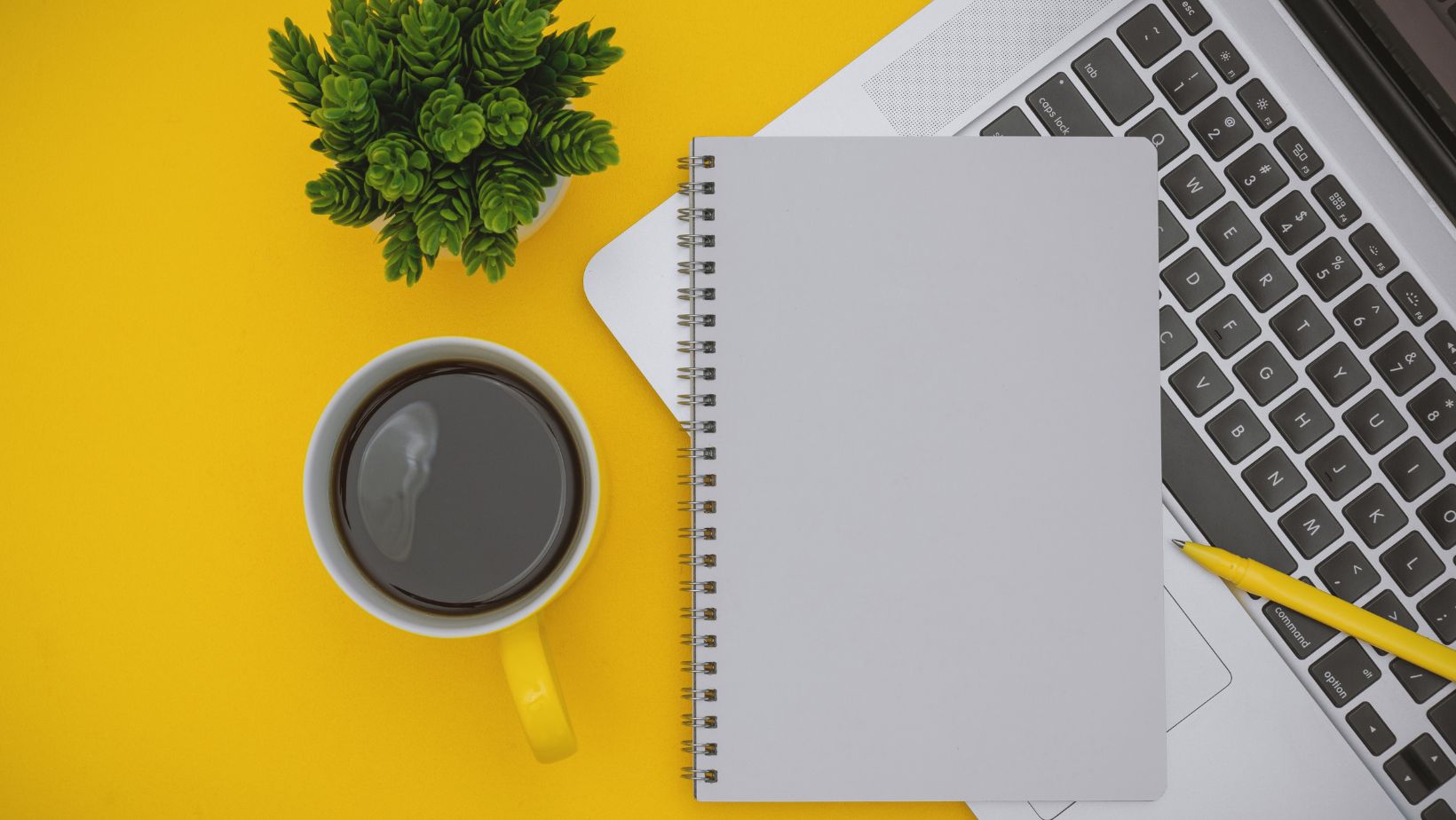 Laptop and coffee mug on yellow background