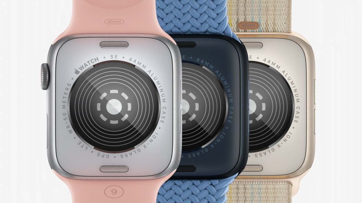 three Apple Watch SE watches. the watch on the left features a pink rubber band, the watch in the middle features a blue woven band, and the watch on the right has a beige woven band