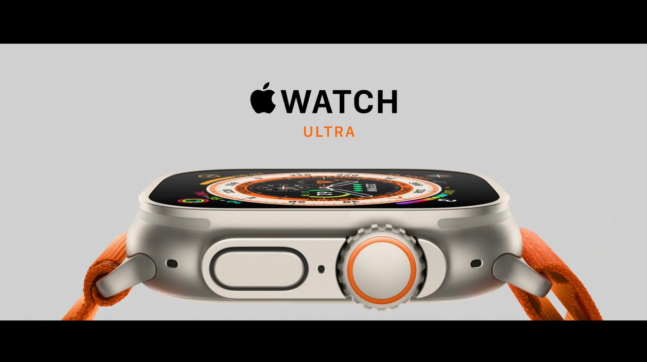 Apple watch logo above the word "ultra" in orange text. Beneath the text is a closeup of the Apple Watch Ultra watch face