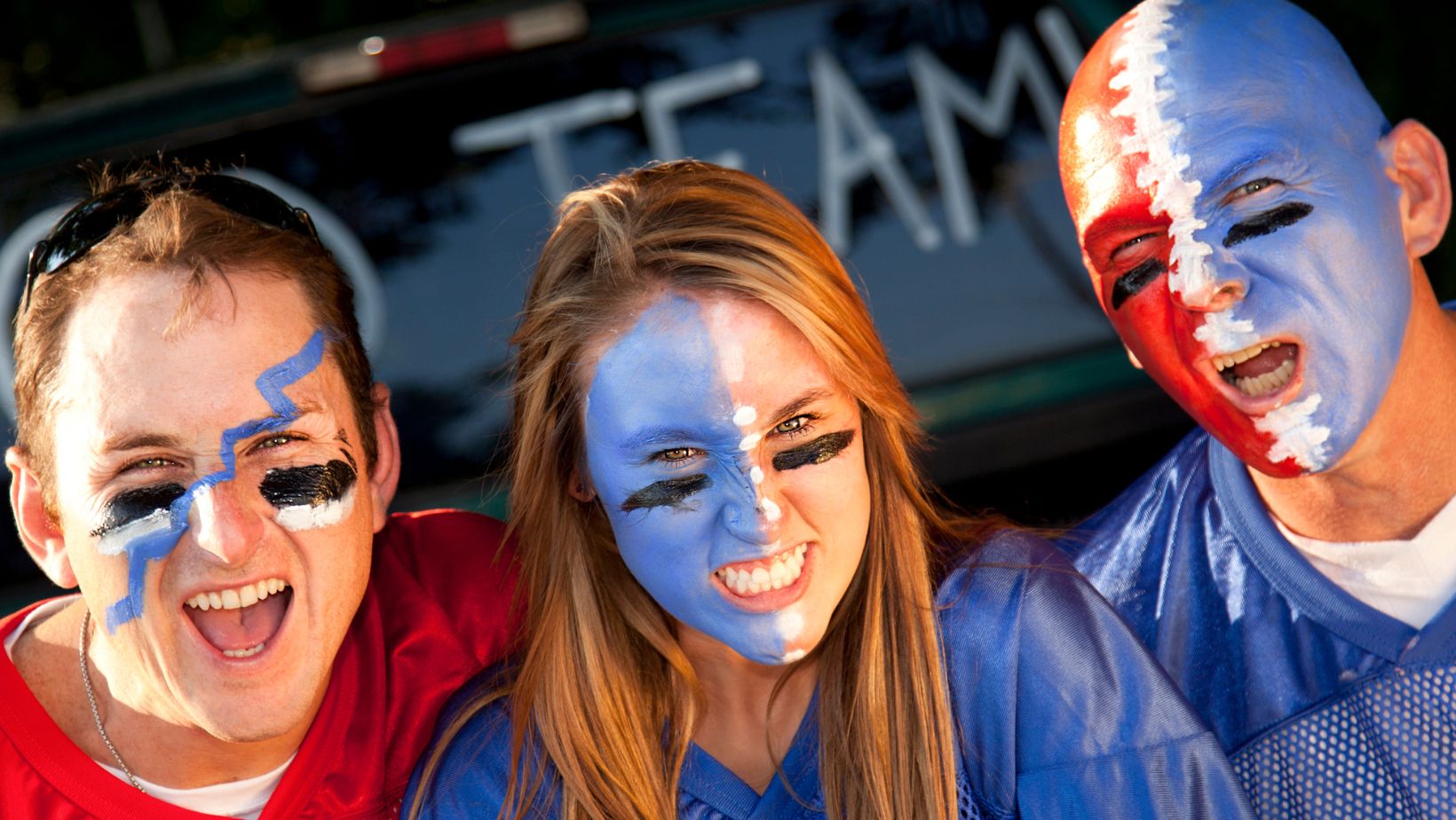 two men and a woman with blue and red face paint