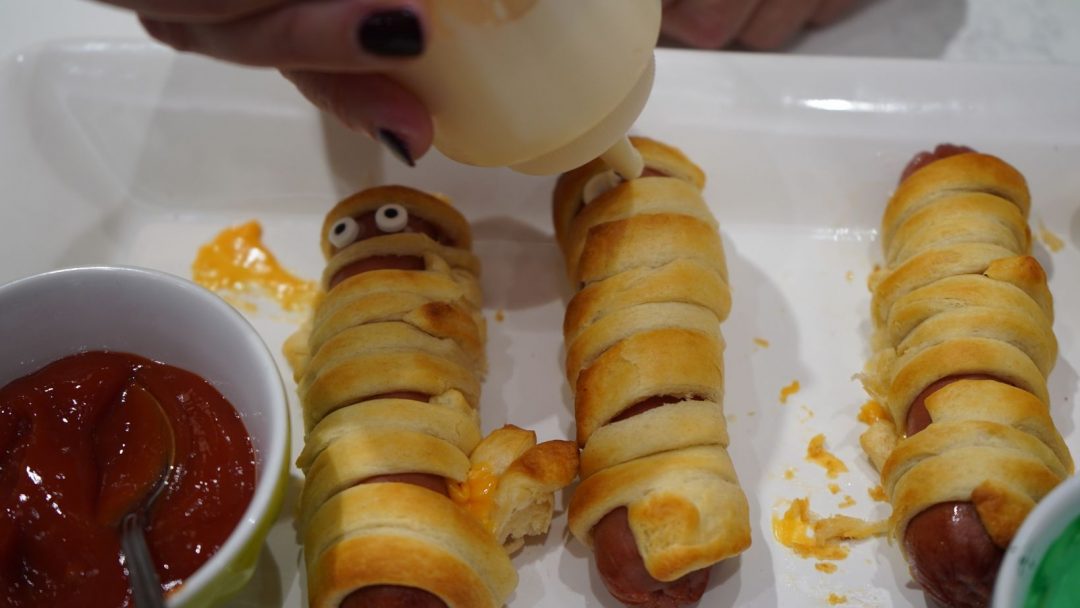 hot dog mummies being decorated with mayonnaise