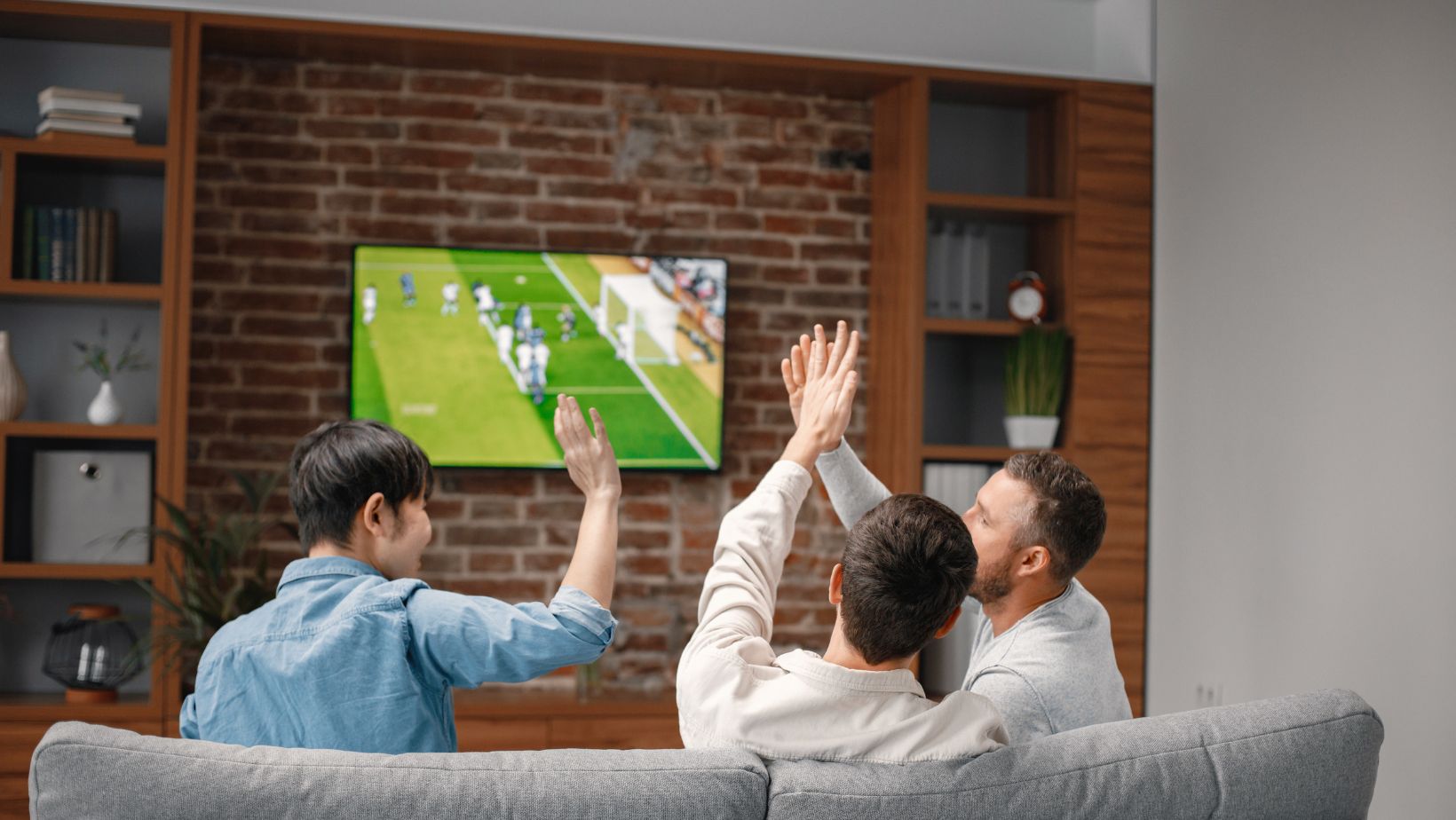 Three men watching football on TV