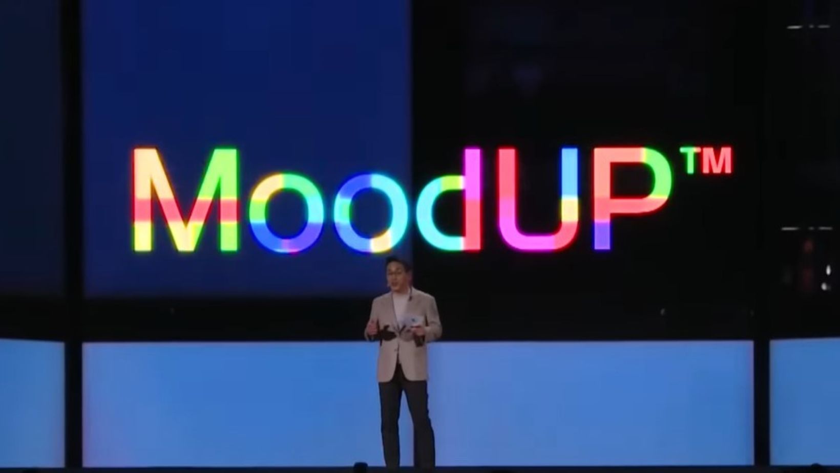lg CEO stands in front of a screen that reads "MoodUp" in rainbow lettering