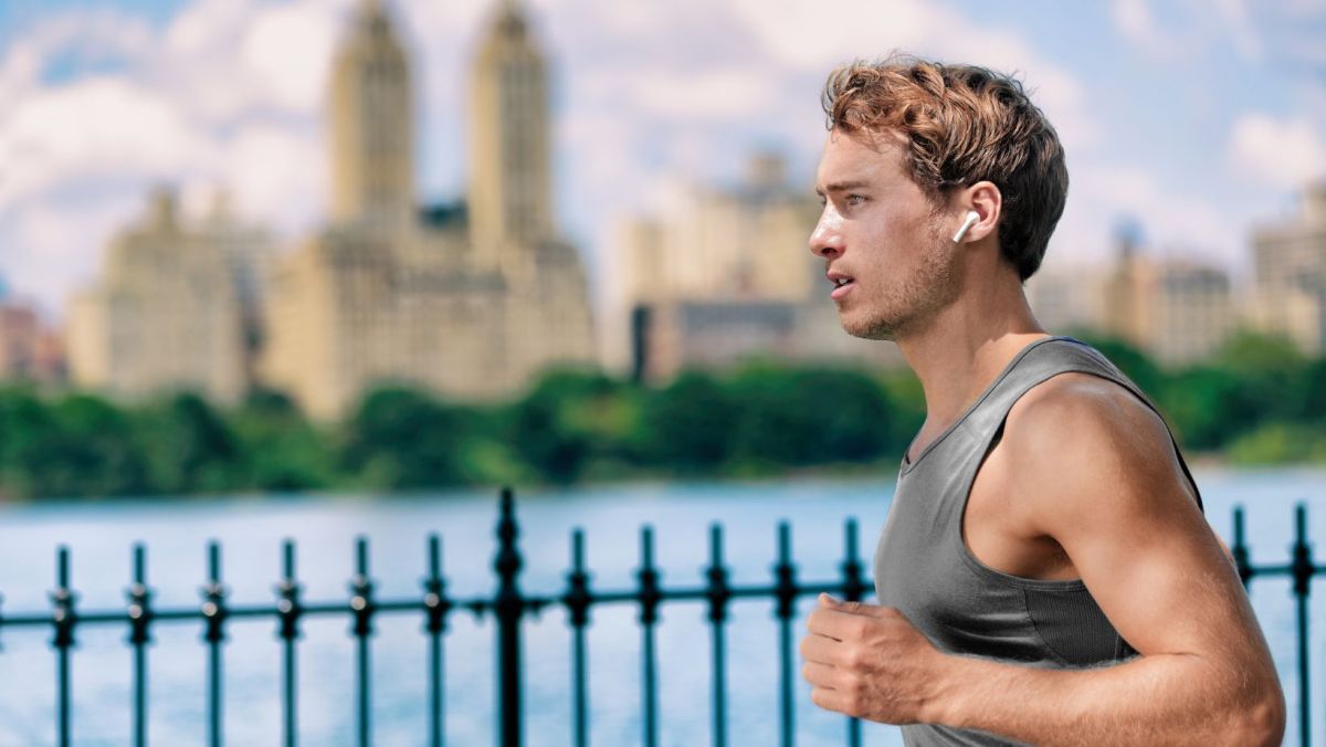 Jogger listening to wireless headphones jogging outside