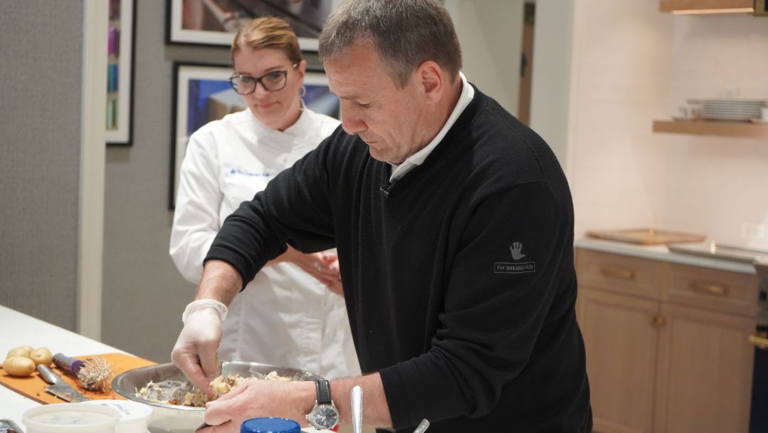 Abt's Tim Hendricks mixes potato salad while Chef Susan from BlueStar watches.