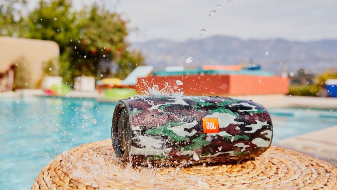 camo JBL Flip 6 speaker being splashed with water