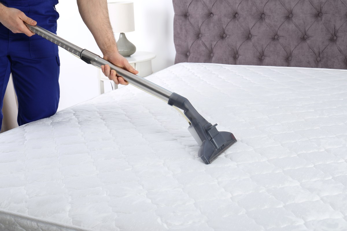 Picture of man vacuuming his mattress.