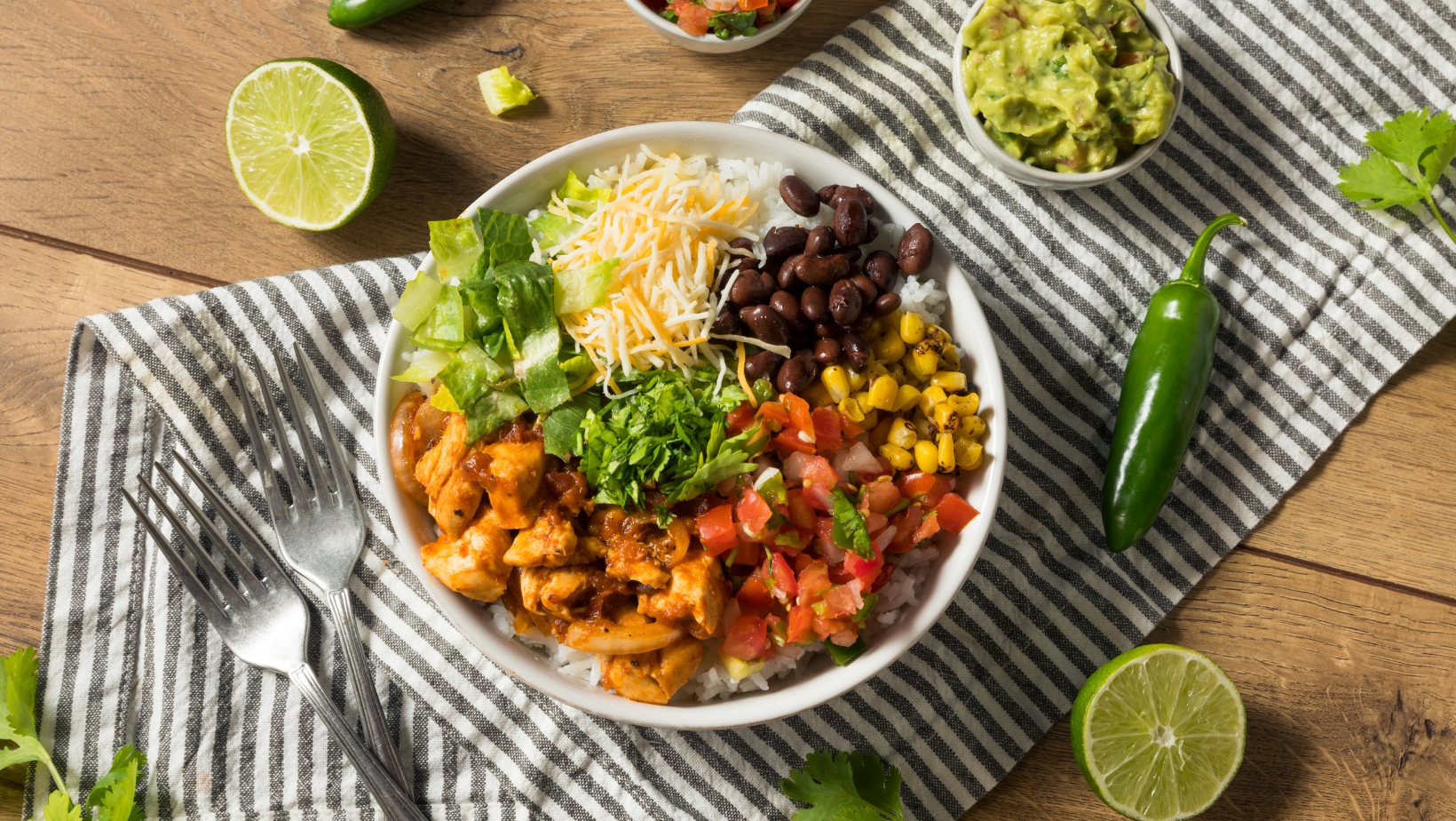 A chicken burrito with cilantro lime rice. In the bowl you can see chicken, tomatoes, corn, black beans and cheese.