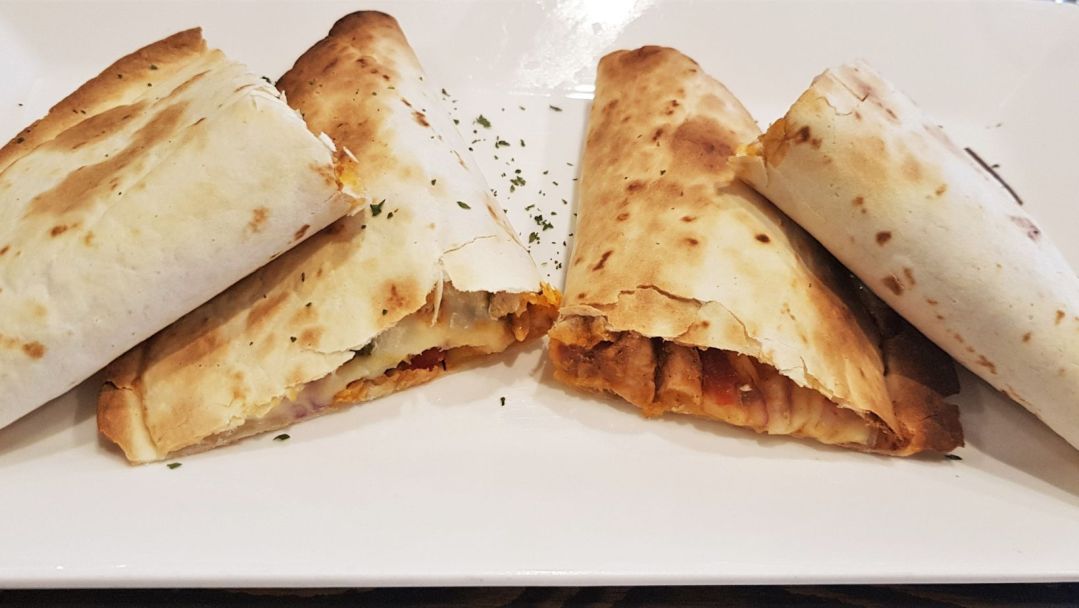 Air fryer chicken quesadillas cut in four triangles on a white plate
