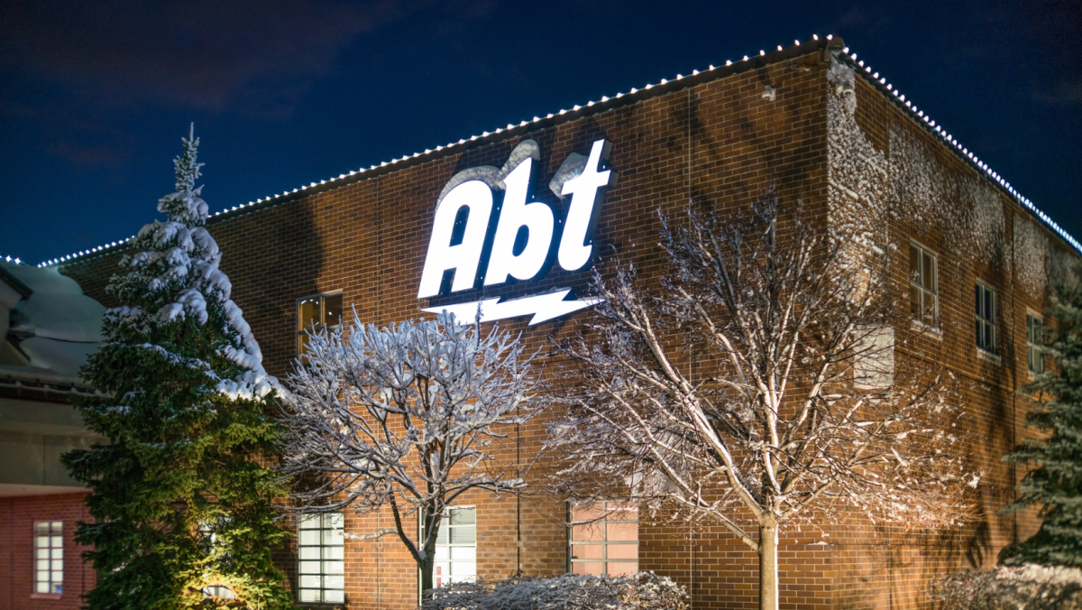 A night time shot of the Abt store in winter, with snowy trees and white string lights.