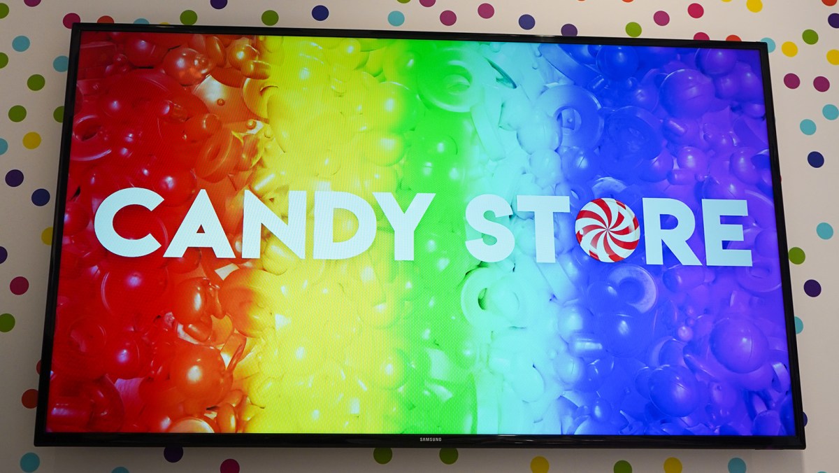 A screen with a rainbow patterned display that reads "CANDY STORE"