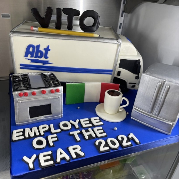 A photo of Vito's employee of the year 2021 cake featuring appliances, a mug of coffee, an Italian flag, and an Abt truck.