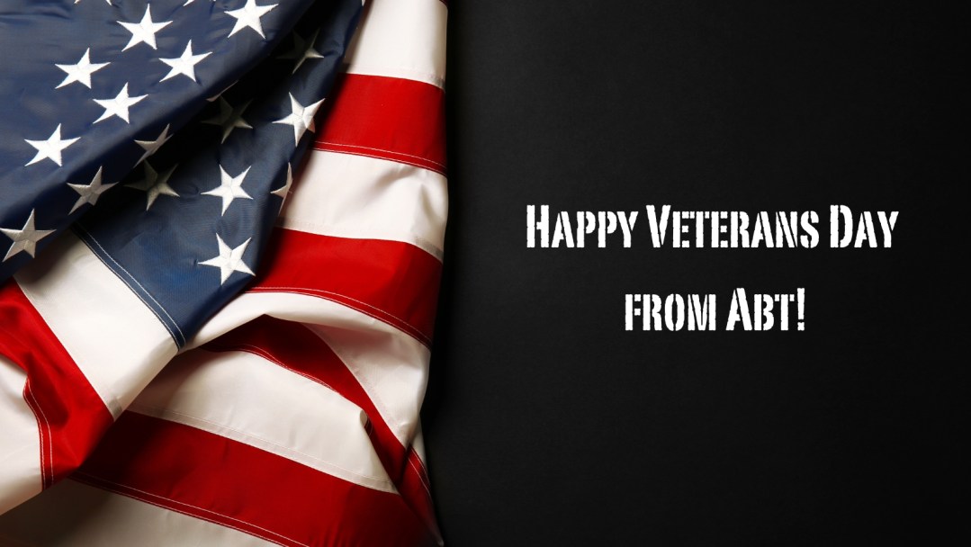 A black background with an American flag on the left side and the text "Happy Veterans Day From Abt!"