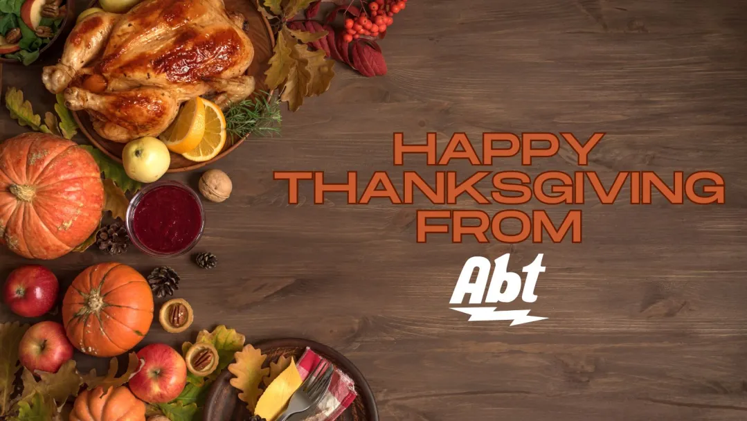 flat lay of thanksgiving dinner with orange text that reads "happy Thanksgiving from Abt"