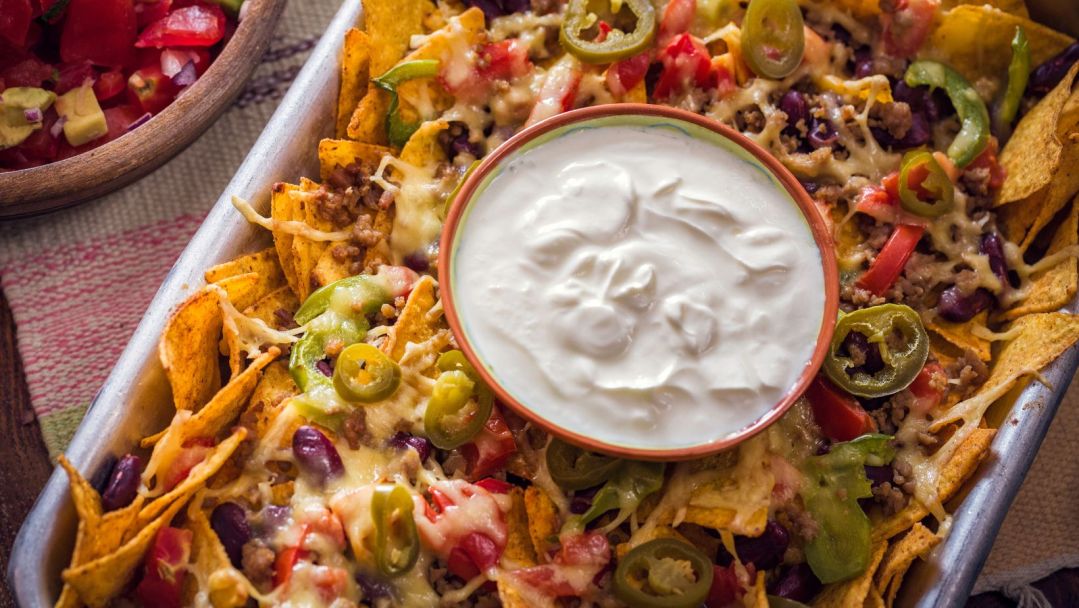Queso Blanco Nacho Tray with a dish of sour cream in the middle