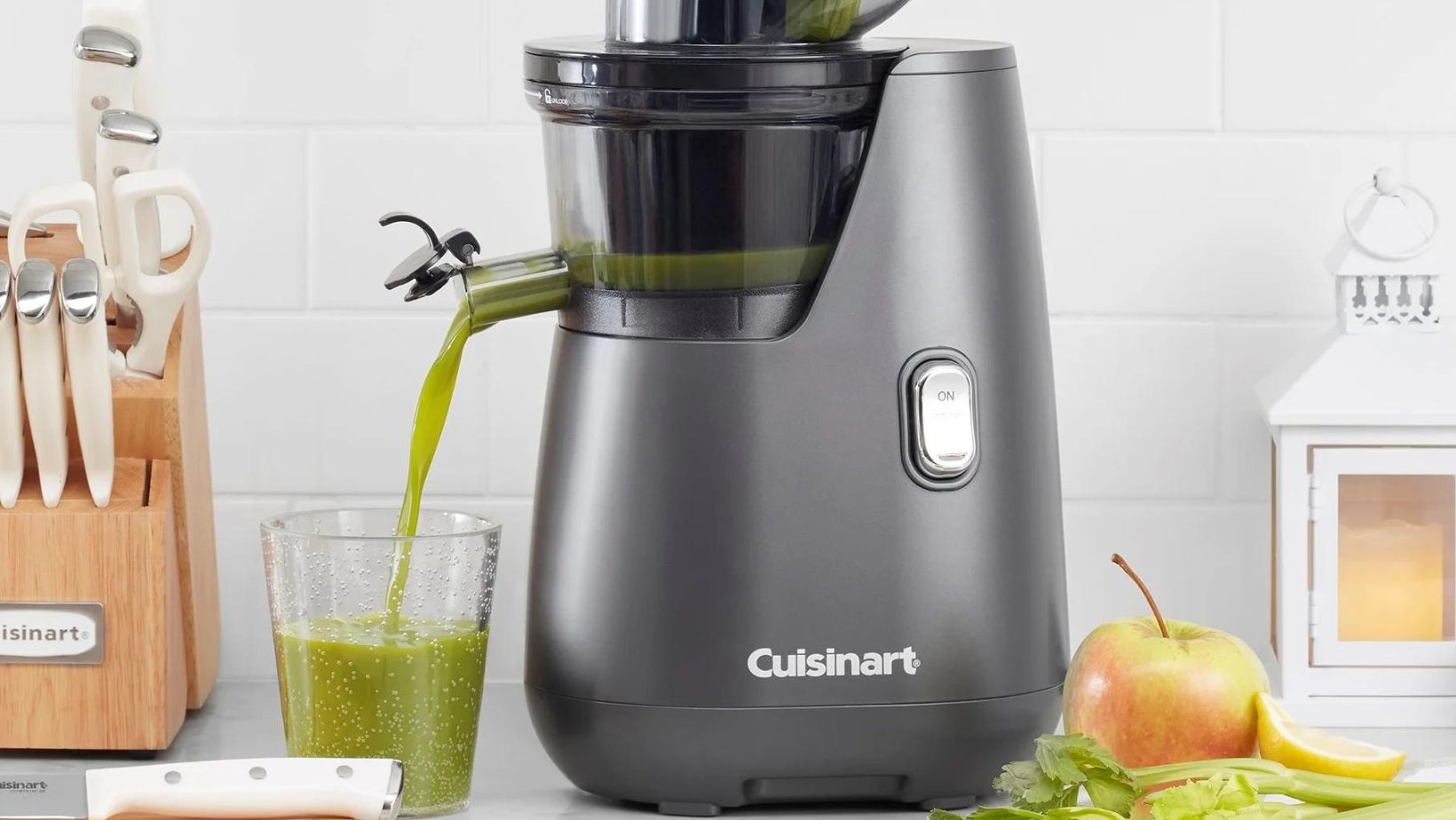 A Cuisinart Juicer that's producing green juice on a countertop