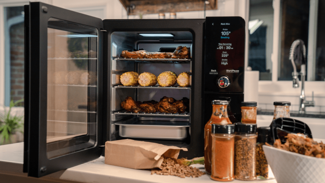 Ge Profile Smart Indoor Smoker with food and spices on the counter.