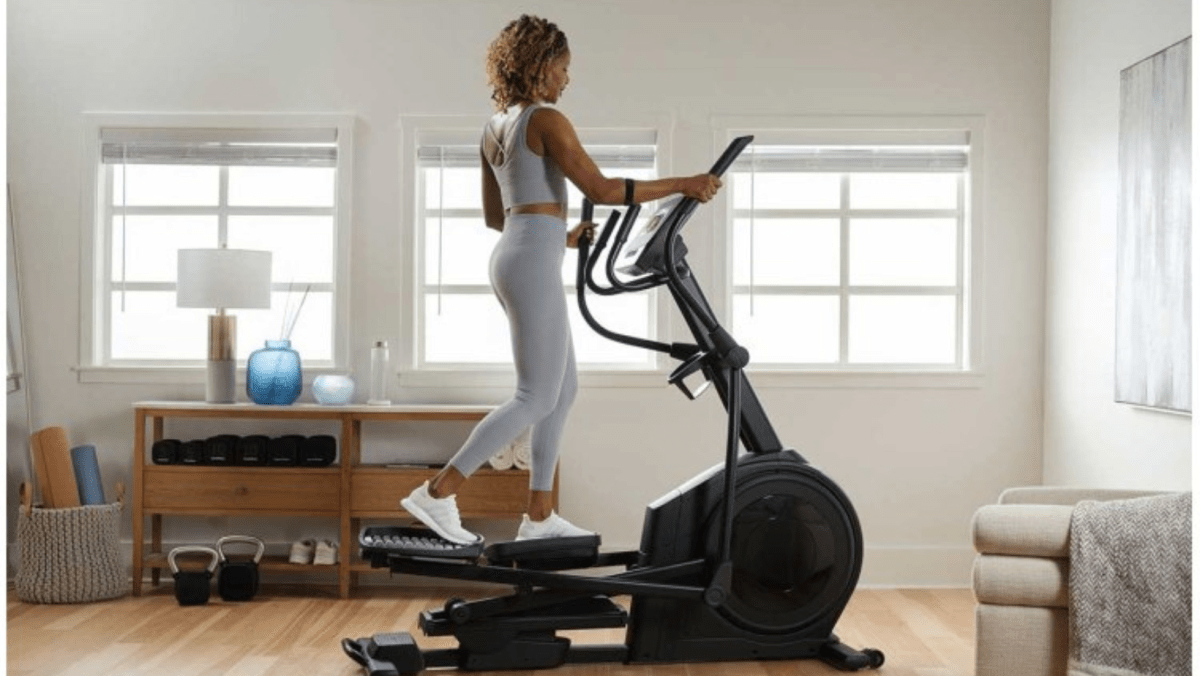 Woman exercising on an elliptical at home.