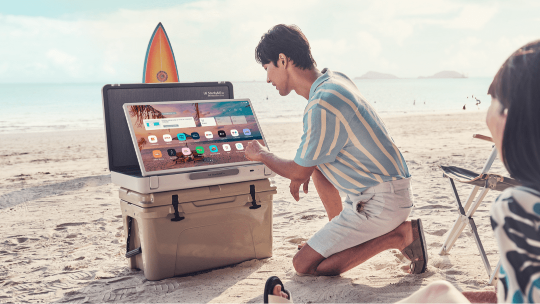 Man using LG StanbyME Go on the beach.