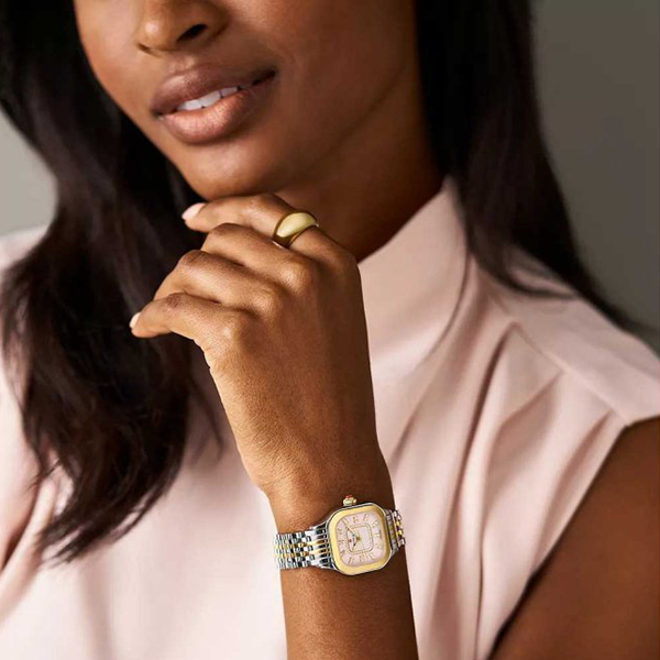 A woman wearing a silver and gold watch on her wrist as a Mother's Day gift.