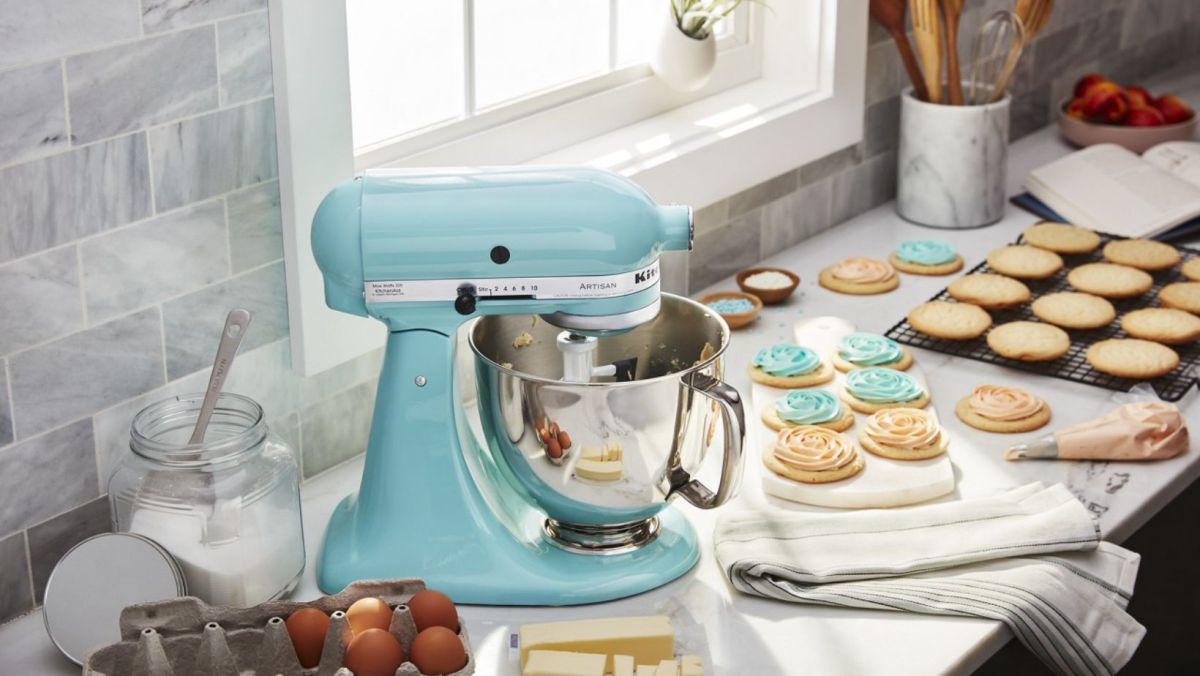An Aqua Sky KitchenAid Mixer on a countertop beside cookies